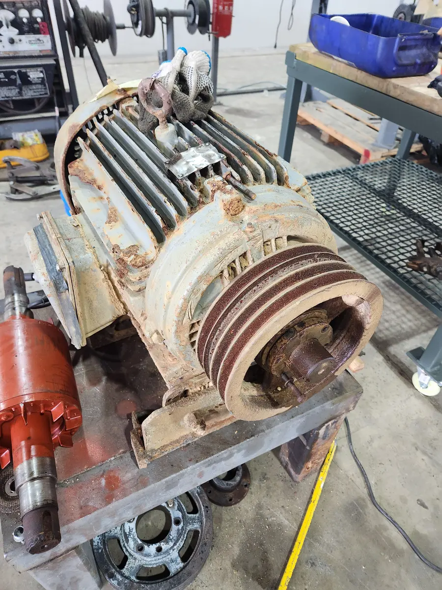 Corroded three-phase electric motor with a rusted multi-groove sheave before repair