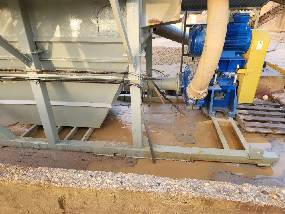 Slurry pump and motor installed beside a sand and gravel processing hopper at an aggregate wet-processing plant