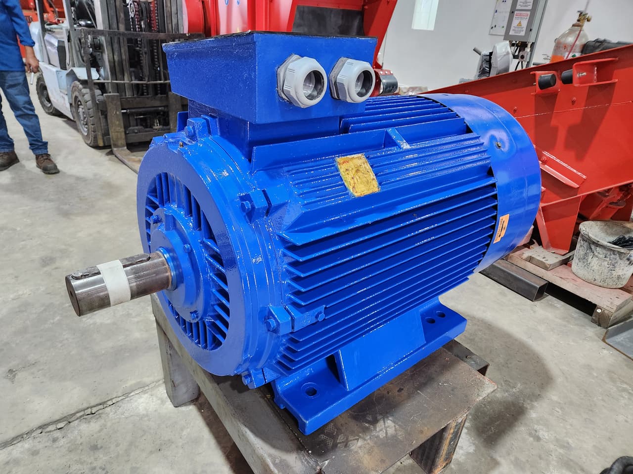 Blue three-phase electric motor on a workshop bench